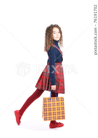 Child with a yellow packaging checkered texture  isolated on white background. Holiday present, shopping. 76191702