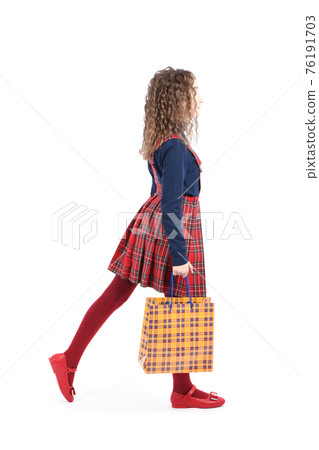 Child with a yellow packaging checkered texture  isolated on white background. Holiday present, shopping. 76191703