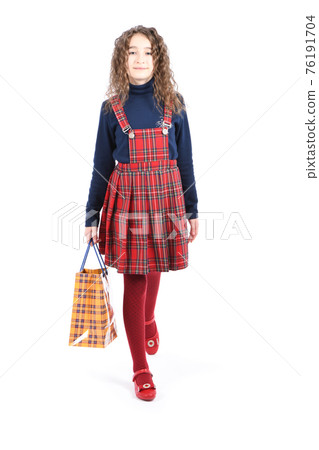 Child with a yellow packaging checkered texture  isolated on white background. Holiday present, shopping. 76191704