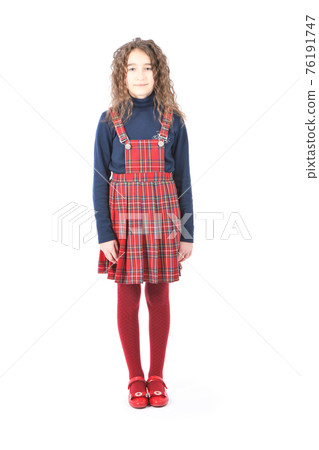 Portrait of adorable smiling schoolgirl with curl hair standing isolated on a white 76191747