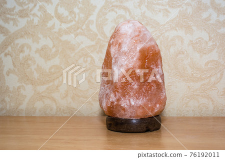 Pink salt lamp on the table in the bedroom 76192011
