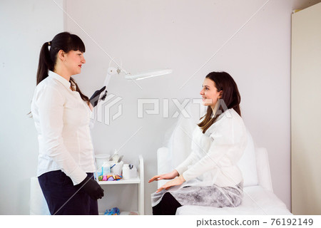 Professional cosmetologist woman in office consulting young female client. Professional cosmetologist woman in office consulting young female client. 76192149
