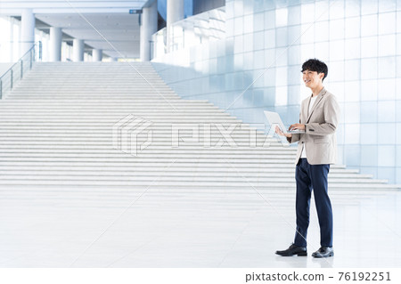 有一台膝上型計算機的年輕商人在辦公室 76192251