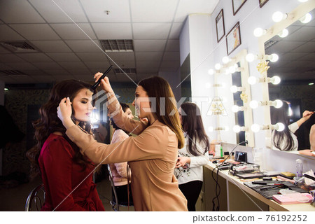 Process of making makeup. Make-up artist working with brush on model face. Portrait of young woman Process of making makeup. Make-up artist working with brush on model face. Portrait of young woman 76192252