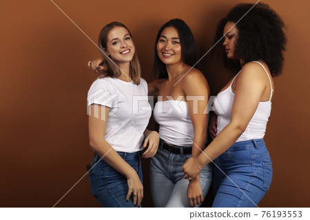 young pretty asian, caucasian, afro woman posing cheerful together on brown background, lifestyle diverse nationality people concept young pretty asian, caucasian, afro woman posing cheerful together on brown background, lifestyle diverse nationality people concept 76193553