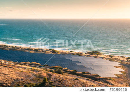Solar panels installed along the coastline at sunset in South Australia 76199636