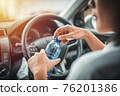 Women drink water during driving in the morning. 76201386