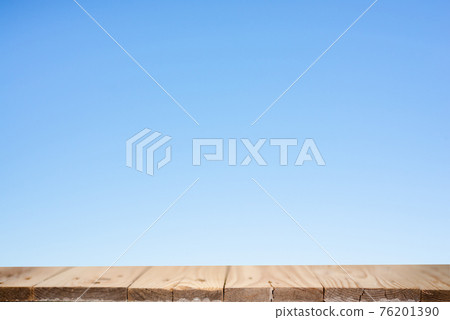 Wood plank table top on blue background 76201390