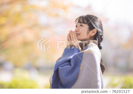 A woman standing in an autumn park 76201527