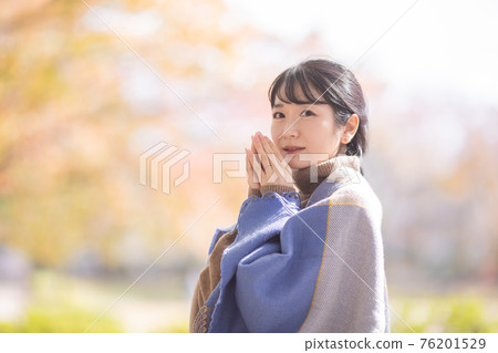 A woman standing in an autumn park 76201529