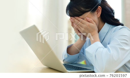 Image of a woman who is sad with a personal computer 76201597