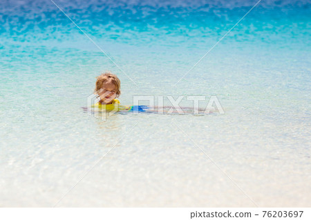 Kids playing on beach. Children play at sea. 76203697