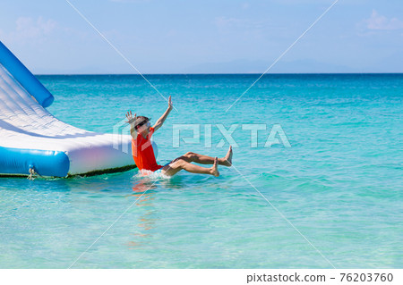 Kids on trampoline on tropical sea beach. 76203760