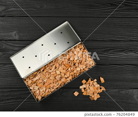 Metal smoker box with wood chips on table Metal smoker box with wood chips on table 76204849