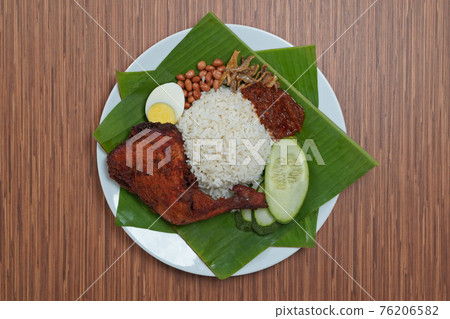 Nasi Lemak dish with chicken drum stick on brown wooden verneer 76206582
