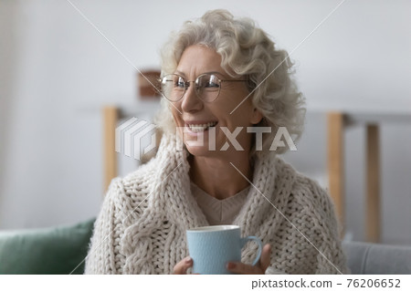 Happy mature 60s lady wrapped in plaid wearing glasses Happy mature 60s lady wrapped in plaid wearing glasses 76206652