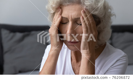 Stressed frustrated elderly woman feeling strong painful headache Stressed frustrated elderly woman feeling strong painful headache 76206872