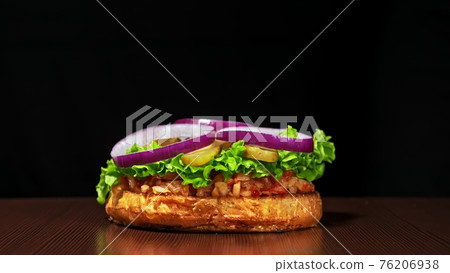 Craft burger is cooking on black background. Consist: sauce salsa, lettuce, red onion, pickle, cheese, chilli green pepper, bun, marbled meat beef. Craft burger is cooking on black background. Consist: sauce salsa, lettuce, red onion, pickle, cheese, chilli green pepper, bun, marbled meat beef. 76206938