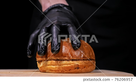 Craft burger is cooking on black background. Consist: sauce, lettuce, tomato, red onion, pickle, cheese, bacon, air bun and marbled meat beef. 76206957