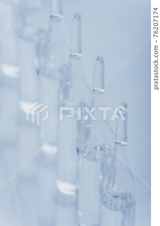 Glass medical ampoule vial for injection. Medicine is dry white drug penicillin powder or liquid with of aqueous solution in ampulla. Close up. 76207174