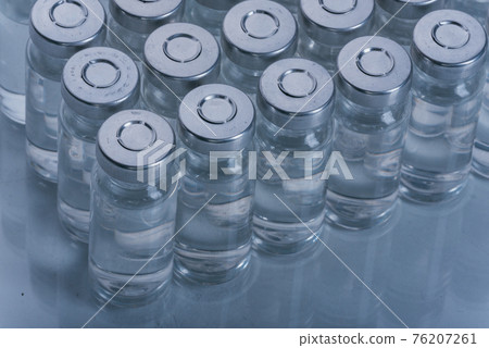 Glass medical ampoule vial for injection. Medicine is dry white drug penicillin powder or liquid with of aqueous solution in ampulla. Close up. 76207261
