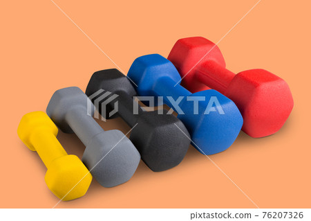 many dumbbells of different colors, stand in a row according to weight seniority, on a colored background, concept many dumbbells of different colors, stand in a row according to weight seniority, on a colored background, concept 76207326