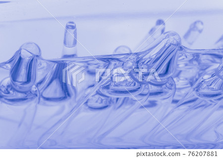 Glass medical ampoule vial for injection. Medicine is liquid sodium chloride with of aqueous solution in ampulla. Close up. Bottles ampule multicolor. Glass medical ampoule vial for injection. Medicine is liquid sodium chloride with of aqueous solution in ampulla. Close up. Bottles ampule multicolor. 76207881