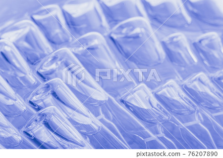 Glass medical ampoule vial for injection. Medicine is liquid sodium chloride with of aqueous solution in ampulla. Close up. Bottles ampule multicolor. 76207890