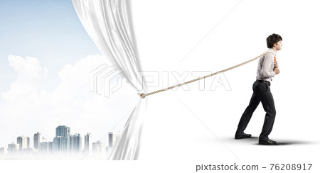 Young man opening white curtain and presenting modern city landscape Young man opening white curtain and presenting modern city landscape 76208917