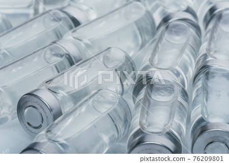 Glass medical ampoule vial for injection. Medicine is dry white drug penicillin powder or liquid with of aqueous solution in ampulla. Close up. 76209801