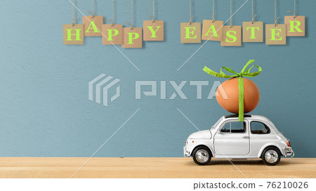 Retro car carrying an easter egg on the roof. Copy space 76210026
