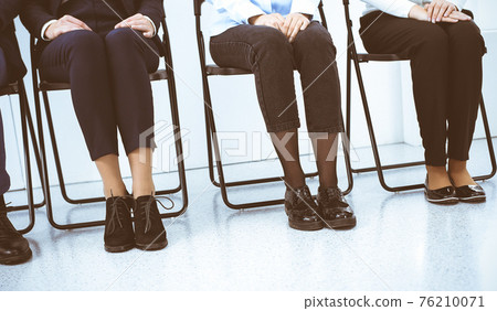 Group of business people sitting in office and waiting for job interview while using gadgets, close-up. Recruiting and headhunting concepts Group of business people sitting in office and waiting for job interview while using gadgets, close-up. Recruiting and headhunting concepts 76210071