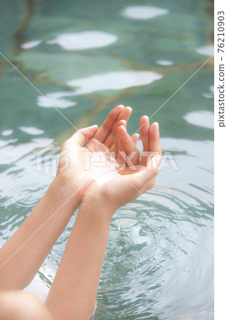 A woman bathing in an open-air bath 76210903