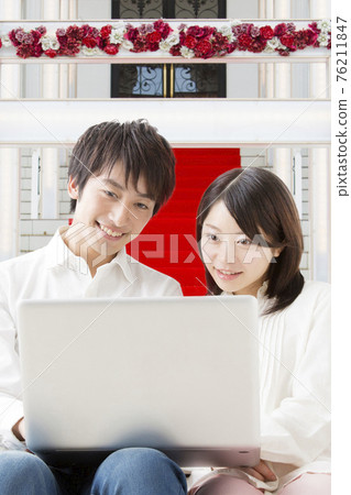 A couple looking at a personal computer 76211847