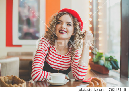 Young stylish woman sitting in cafe, laughing, chatting, enjoying in city street cafe Young stylish woman sitting in cafe, laughing, chatting, enjoying in city street cafe 76212146