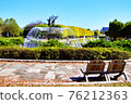 Sit in front of the fountain in the park and take a rest 76212363