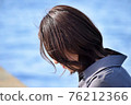 A woman looking down at the beach 76212366