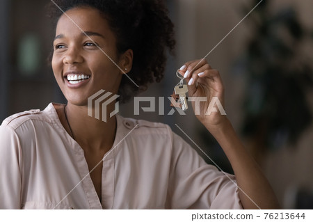 Smiling African American woman hold keys to new home Smiling African American woman hold keys to new home 76213644