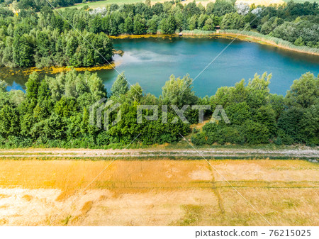 Aerial view with the drone of a blue pond Aerial view with the drone of a blue pond 76215025