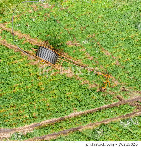 Vertical aerial view with the drone of a huge hose reel Vertical aerial view with the drone of a huge hose reel 76215026