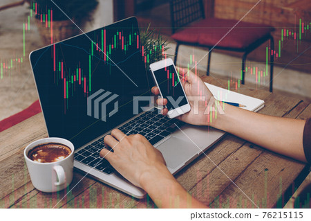 Trader holding in hands a smart phone and researching stock market to proceed right investment solutions. Trader holding in hands a smart phone and researching stock market to proceed right investment solutions. 76215115