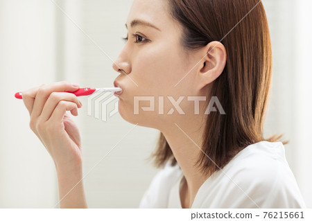Profile of a woman brushing her teeth 76215661