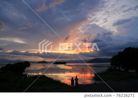 Two people watching the scene of dusk Two people watching the scene of dusk 76216271