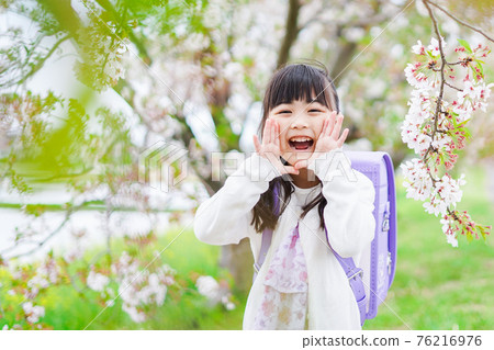 一個背著背包在櫻花盛開時發帖的小女孩 76216976