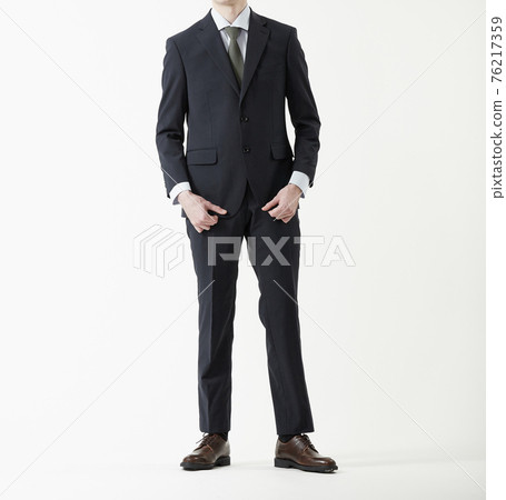 Man standing in suit, white background 76217359