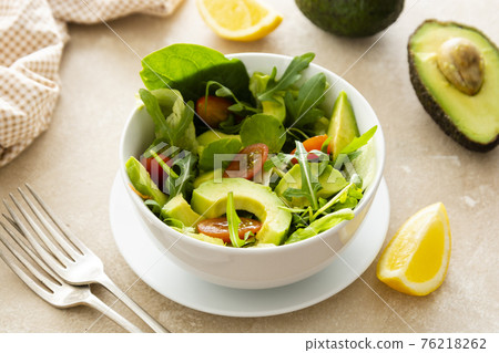 Heathy food salad bowl. Avocado spinach salad with lemon juice and olive oil. Heathy food salad bowl. Avocado spinach salad with lemon juice and olive oil. 76218262