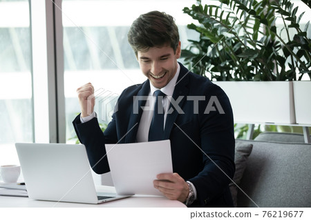 Excited businessman read good news in paperwork 76219677