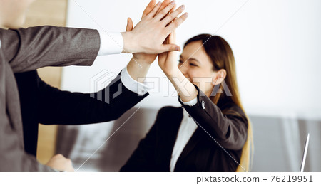 Unknown business people group joining hands in modern office. Businessmen and women making circle with their hands as a team, close-up 76219951