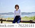 一個女人在大海和山脈的背景下爬籬笆 76220183