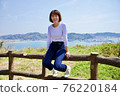 一個女人在海山背景下爬籬笆的全身 76220184